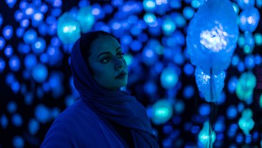 Woman admiring light display at the National Museum of Qatar.