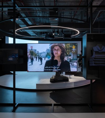 Photo of the Al Jazeera studio with a TV screen in the middle showing late Al Jazeera journalist Shireen Abu Akleh