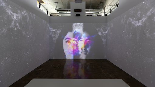 A room with projection display that showcases two women.