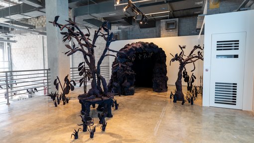 An installation that depicts a dark black forest.