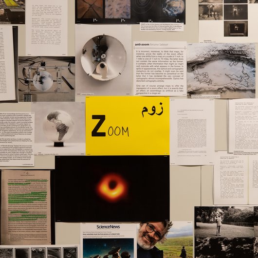 A collection of documents surround a yellow paper in the middle that has the word 'Zoom' written on it.