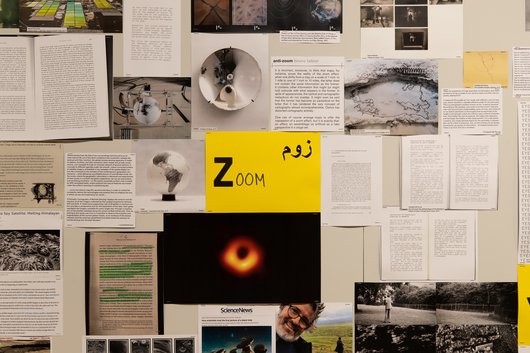 A collection of documents surround a yellow paper in the middle that has the word 'Zoom' written on it.