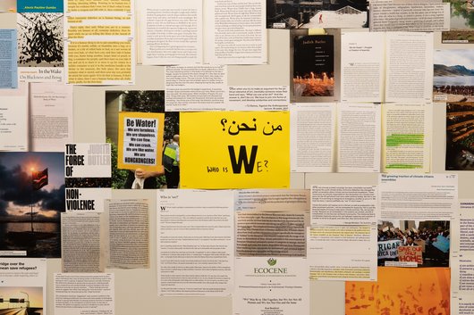 A collection of documents surround a yellow paper in the middle that has 'Who is We?' written on it.