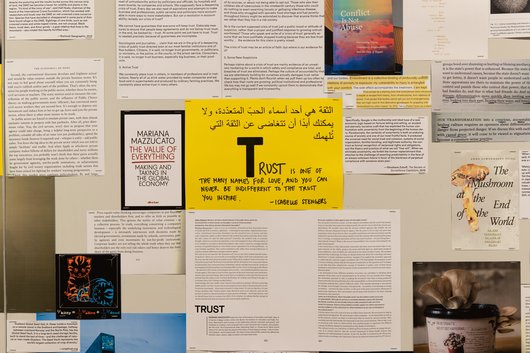 A collection of documents surround a yellow paper in the middle that has the word 'Trust' written on it.