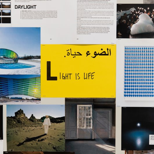 A collection of documents surround a yellow paper in the middle that has the word 'Light is Life' written on it.