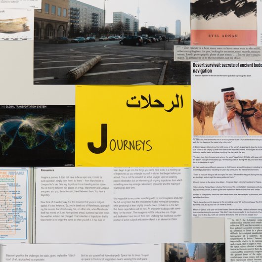 A collection of documents surround a yellow paper in the middle that has the word 'Journeys' written on it.