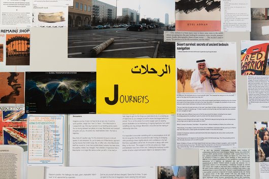 A collection of documents surround a yellow paper in the middle that has the word 'Journeys' written on it.
