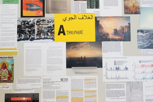 A collection of documents surround a yellow paper in the middle that has the word 'Atmosphere' written on it.