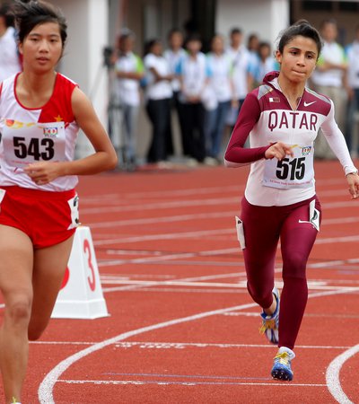Two Olympians running on a running track