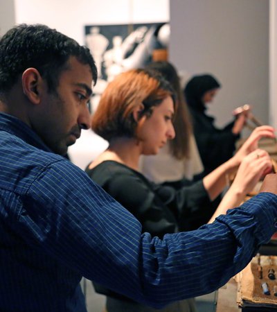 A man and a woman view artefacts in a box during one of Qatar Museums' guided tours