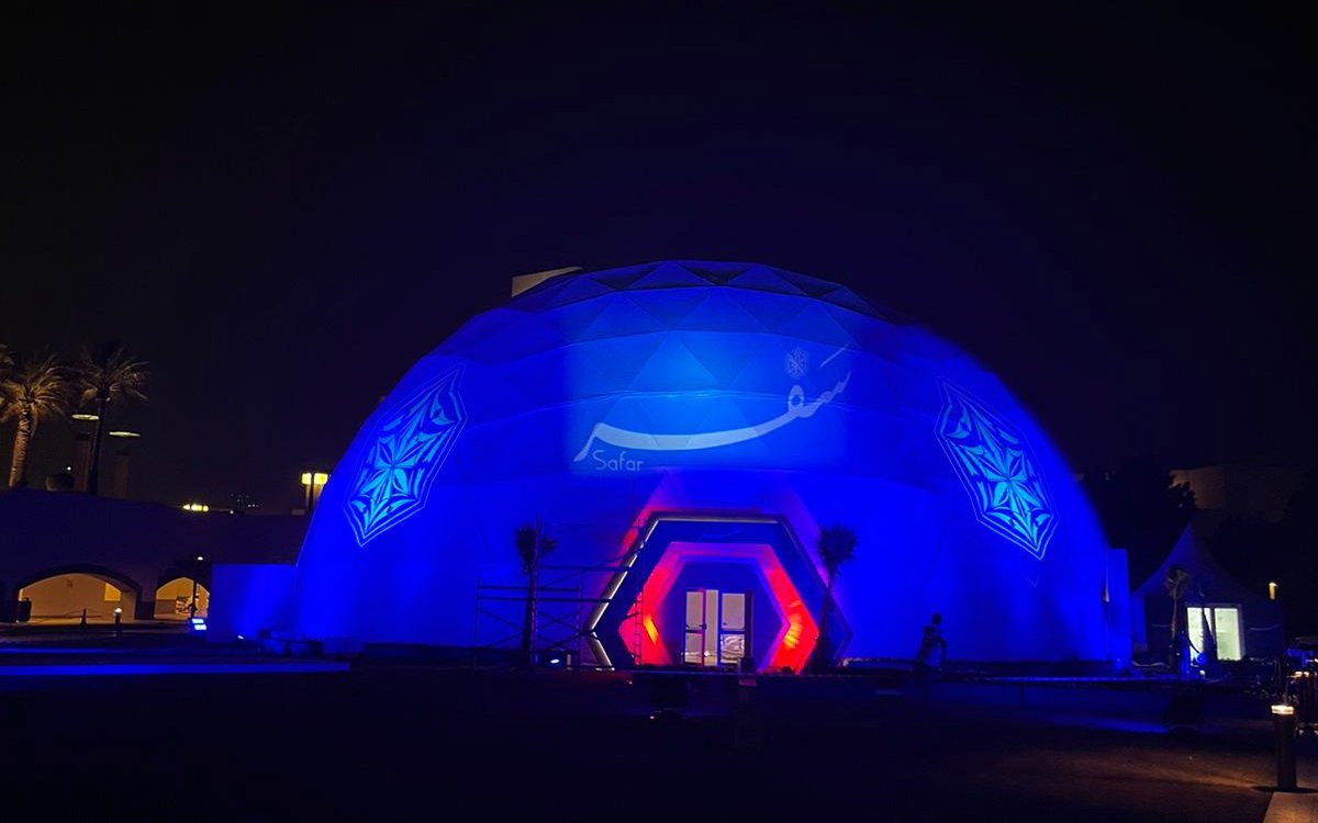 An illuminated building structure in the shape of a sphere.