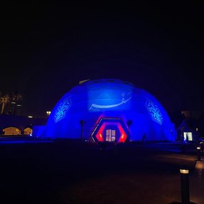 An illuminated building structure in the shape of a sphere.