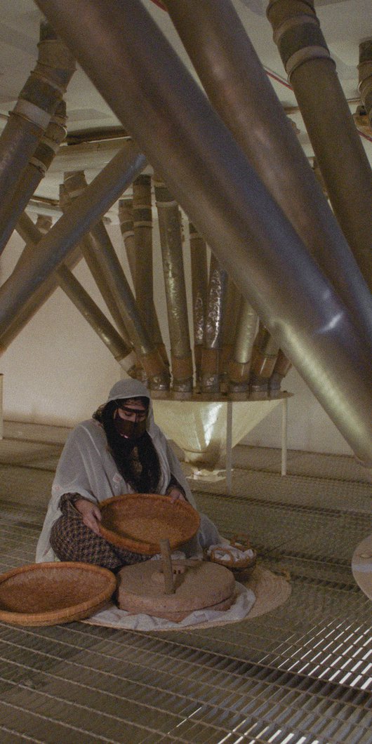 Woman in traditional Qatari dress making flour