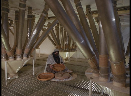 Woman in traditional Qatari dress making flour