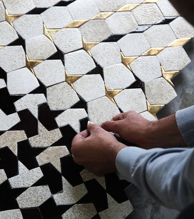 Artisan laying tiles in geometric pattern