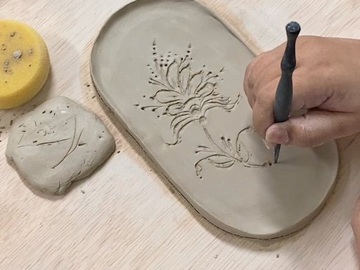hand making tray from clay