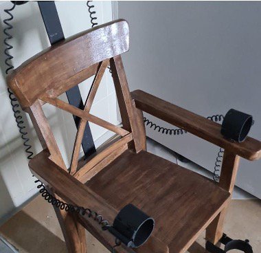 gestapo-like wooden interrogation chair with arm and leg straps