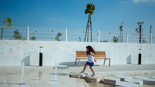 Little girl skipping on stepping stones at the Dadu Gardens.