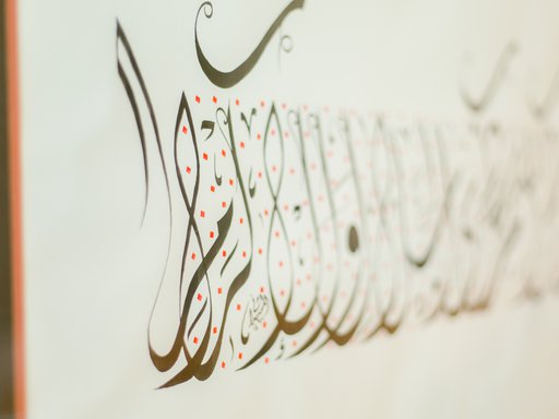 A close up image of Arabic calligraphy written in gold coloured ink