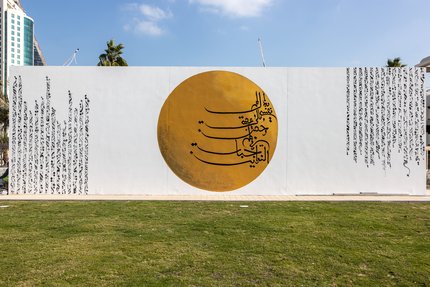 A mural depicting a roundel golden circle with the inclusion of Arabic calligraphy taken from the poetry of Sheikh Jassim bin Mohammed Al-Thani, found