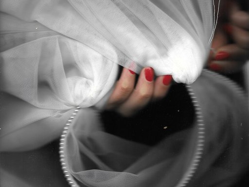 women's hand holding a white sheer fabric