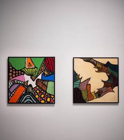 Two colourful abstract paintings in a gallery