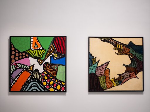 Two colourful abstract paintings in a gallery