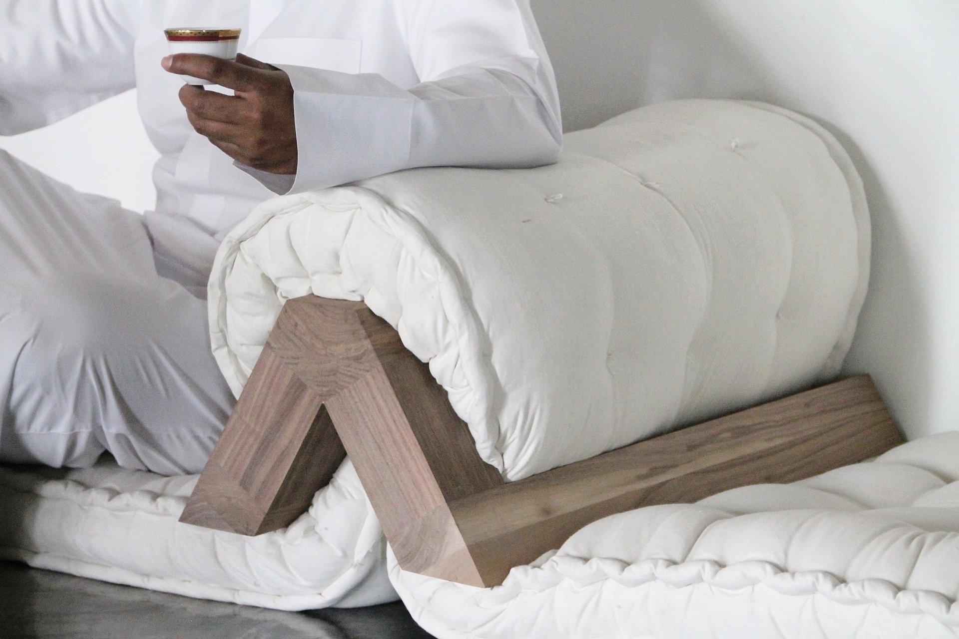 A close up of a wooden arm rest with a cushion.