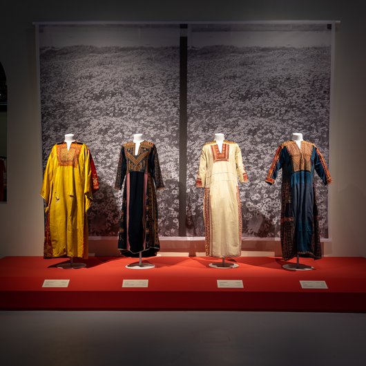 Four colourful Palestinian dresses on display at the QM Gallery - Katara