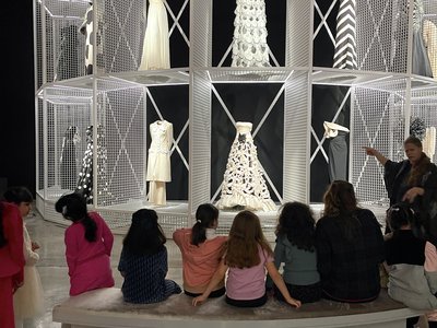 Kids sitting staring at mannequins