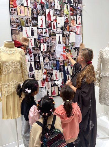 Kids sitting staring at mannequins on display