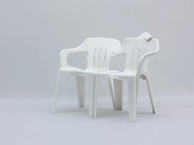 two white monobloc chairs hugging