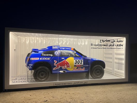 A blue 2011 Volkswagen Race Touareg 3 in a display case.