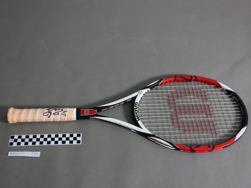 A black, red and white Wilson racquet signed by renowned tennis player Roger Federer.