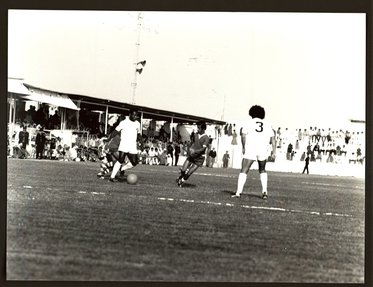 Black and white image of footballer Pele kicking a football mid match.