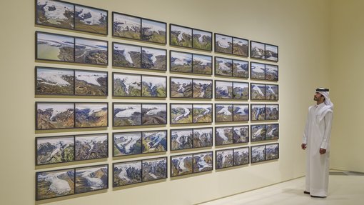A collection of landscape photography displayed on a wall.