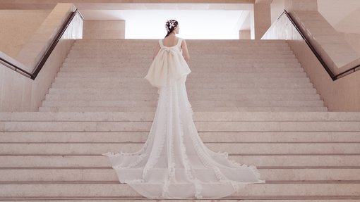 a model in a white dress on stairs