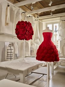 Two red Valentino dresses placed on mannequins in the Valentino workroom.