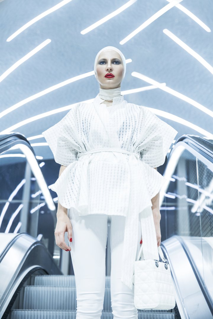 Front view on a model wearing a white top and a white head piece