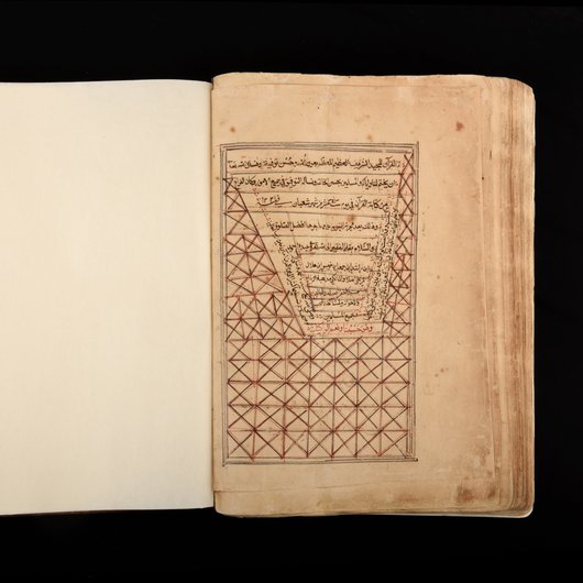 Photo of the last page in the Al Zubarah Qur'an, decorated with geometric shapes and Arabic script, leather binding in the background