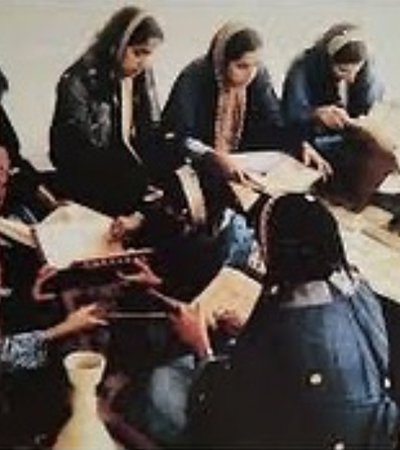 An old photograph showing Amna Mahmoud Al Jaidah teaching a group of female students.