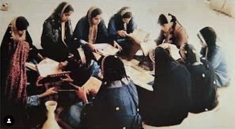 صورة قديمة تظهر فيها آمنة محمود الجيدة تُدرّس مجموعة من الطالبات.