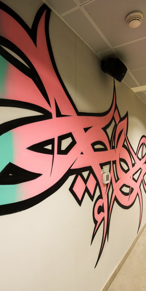 A long shot of a hallway in Lusail decorated with El Seed's mural art