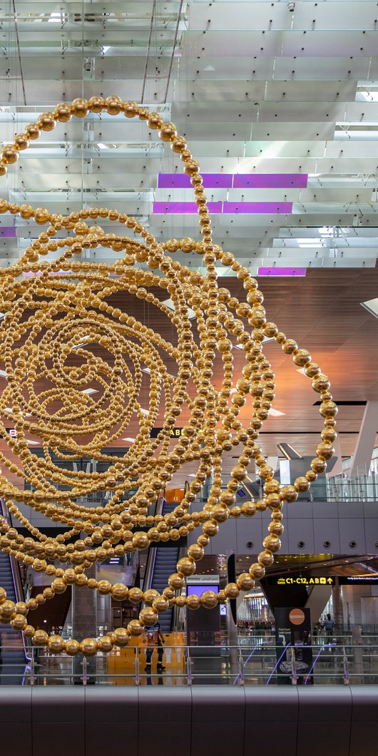 منحوتة "كون" للفنان جان ميشيل أوثونيل. وهي منحوتة ضخمة ذهبية اللون وتتكون من عدة أشكال دائرية متصلة من المركز ومعلقة من السقف داخل مبنى مطار حمد الدول