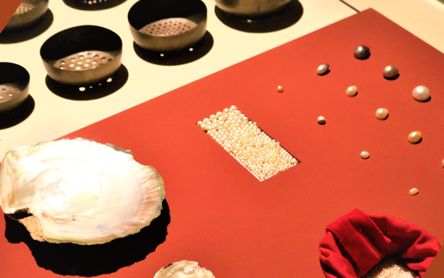 A red display table at the National Museum of Qatar covered in pearls and oysters