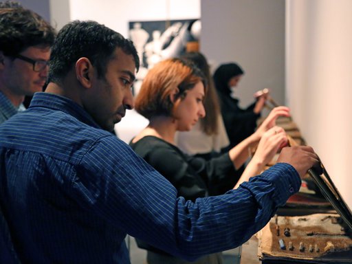 Visitors stopping by to see cased objects at an exhibition