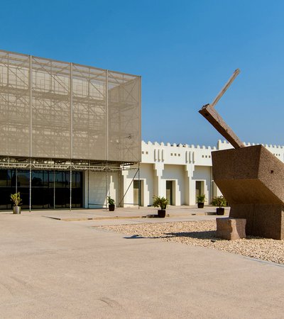 Exterior view of Mathaf entrance with large stone sculptures