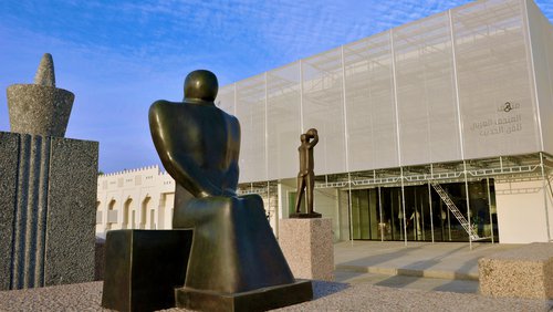 Exterior view of Mathaf: Arab Museum of Modern Art building with a group of three large sculptures positioned in front of it
