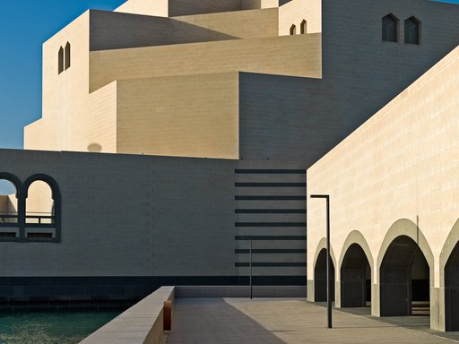 Detail view of the Museum of Islamic Art showing its angular architecture against a bright blue sky