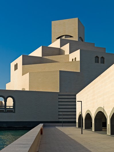 Detail view of the Museum of Islamic Art showing its angular architecture against a bright blue sky